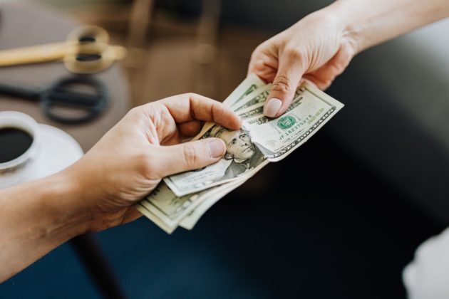 Photo of fiat money being transacted between 2 people. Photo of fiat money being transacted between 2 people.