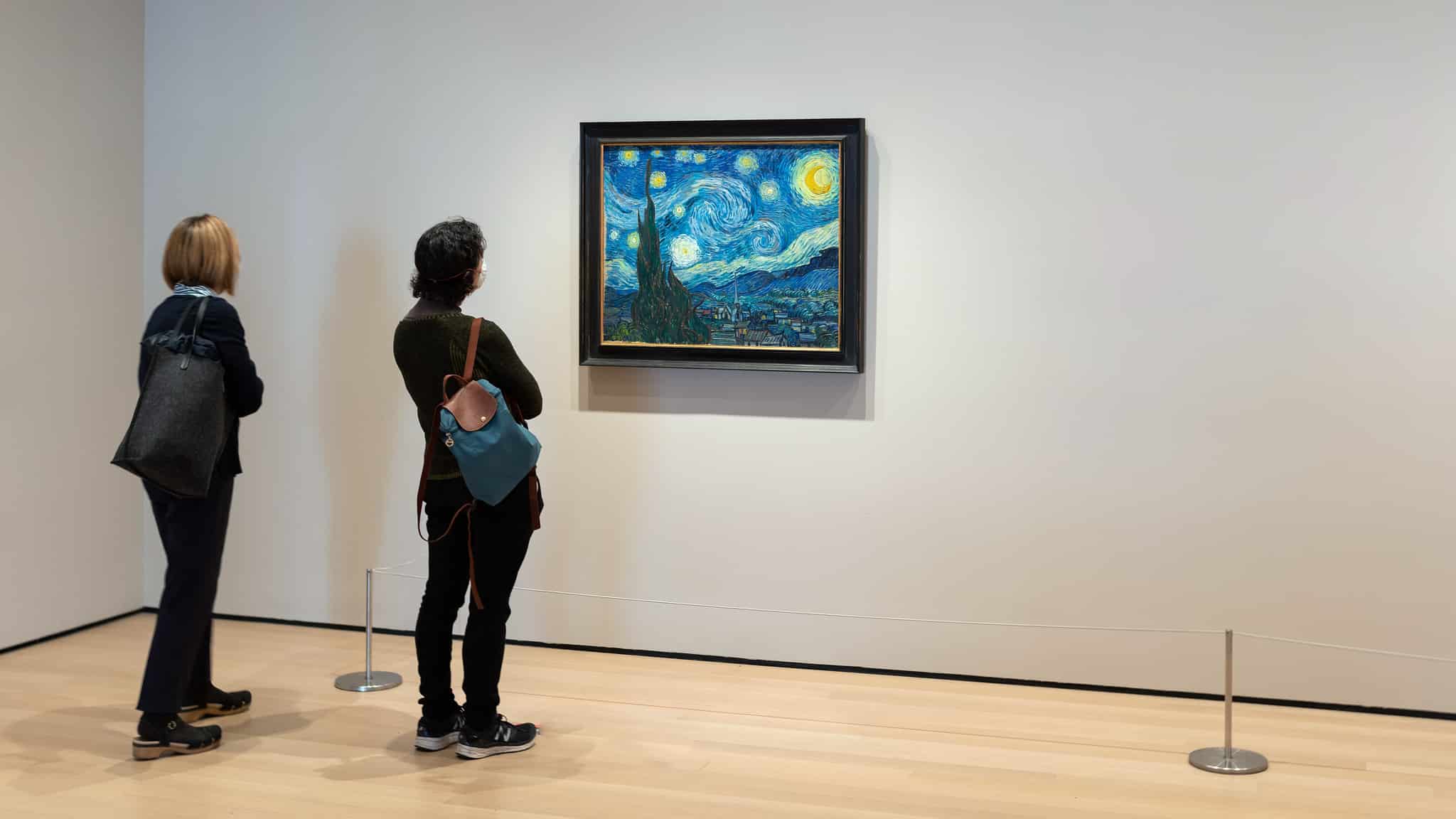 Photo of two people viewing Van Gogh's Starry Night. 