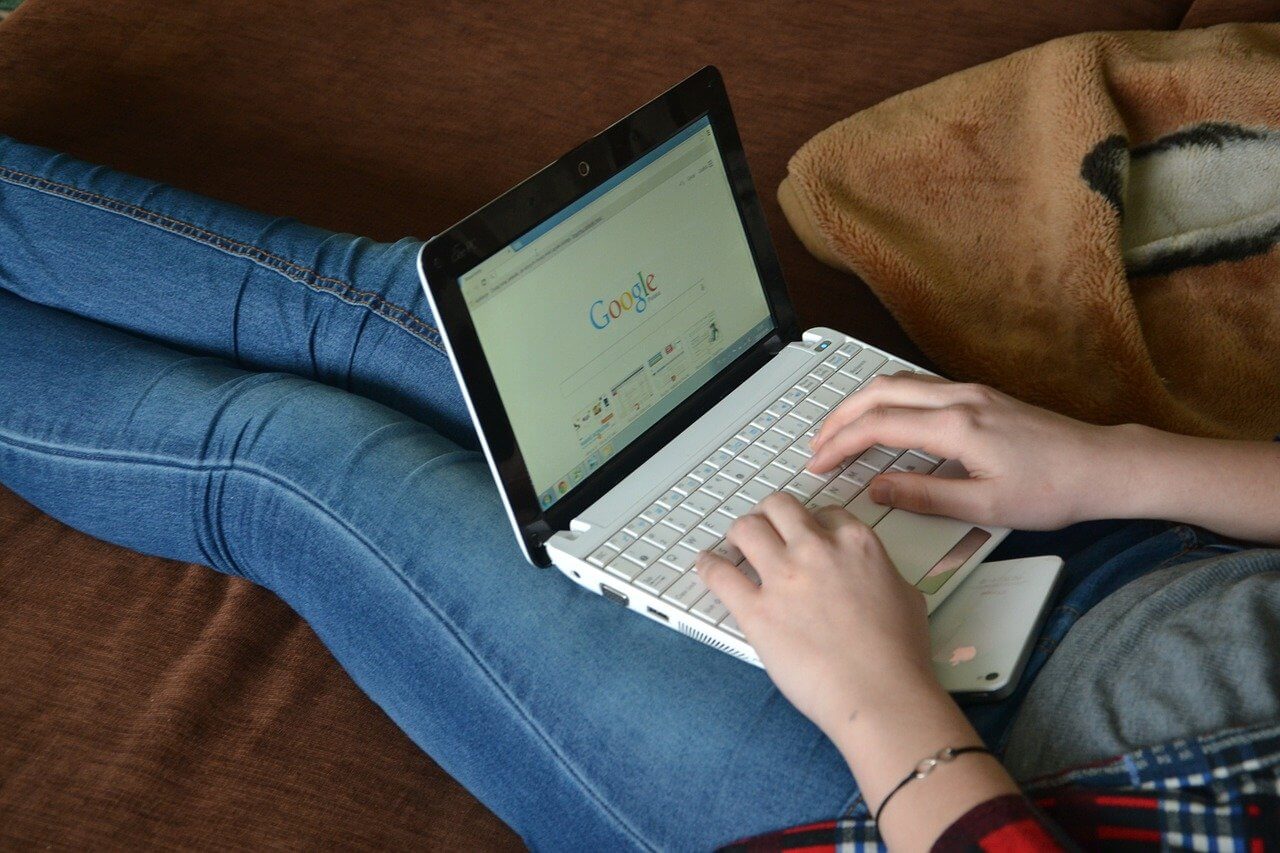 Image of a person typing on a laptop to illustrate how to buy bitcoin with naira