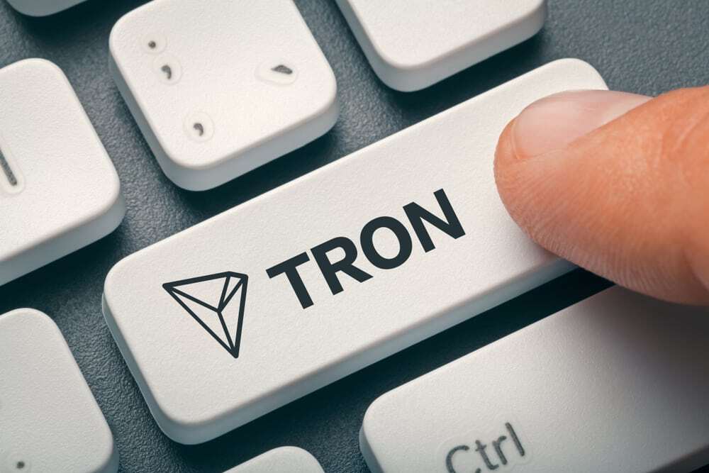 Finger pressing the enter button on a keyboard that says Tron.