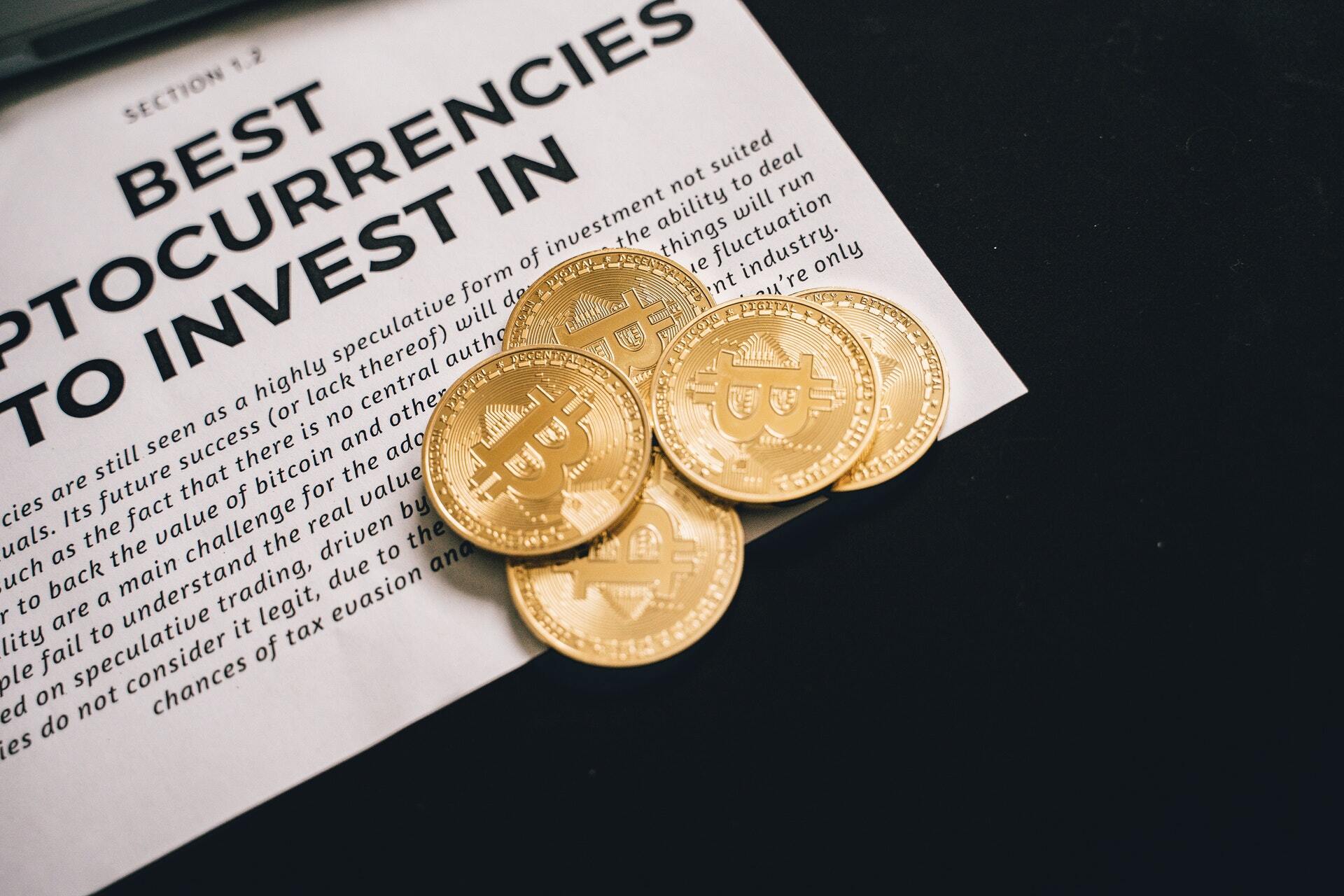 Photo of 5 physical bitcoins on a table to illustrate the topic of reasons for buying bitcoin in Australia in 2021.