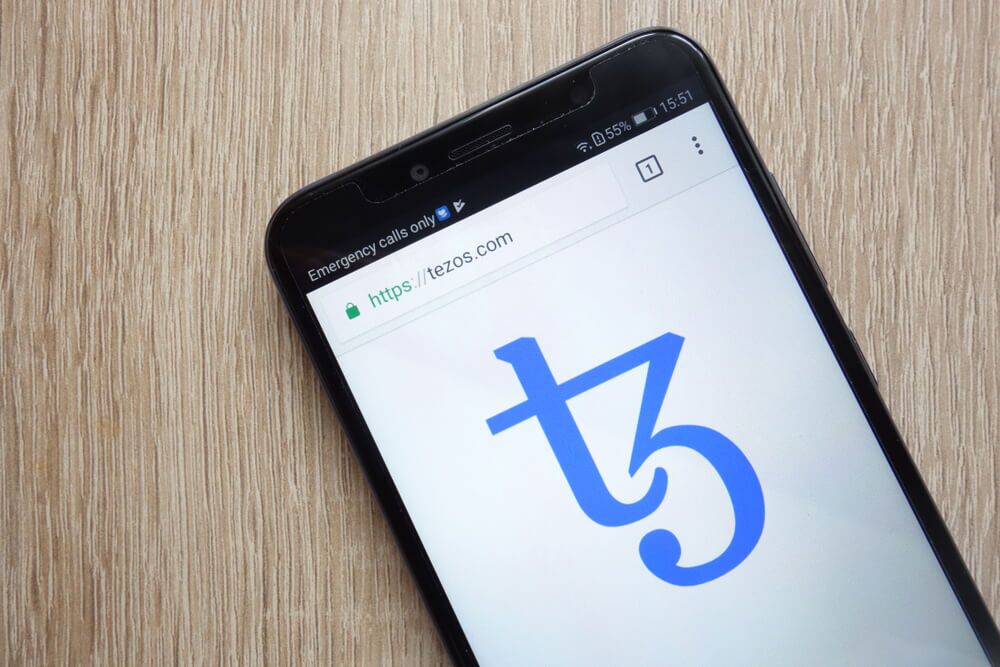 Tezos XTZ logo on phone screen.