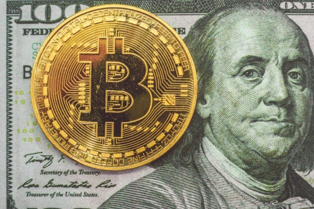 Bitcoin physical representation and the 100 USD bill.