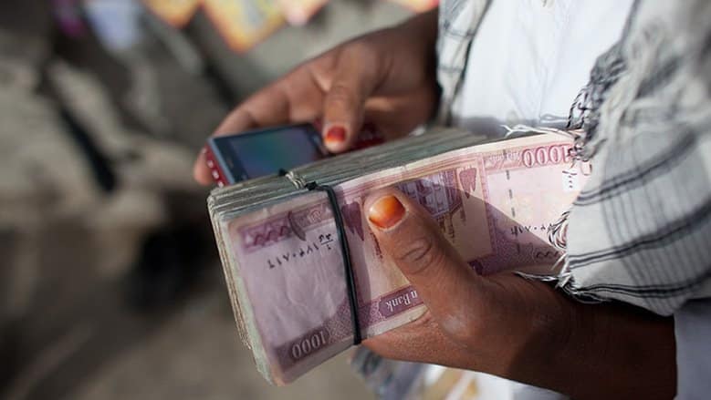 Afghan man counting money.