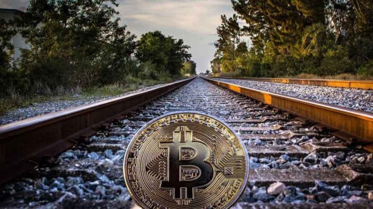 bitcoin-on-trail-1024-576 Bitcoin is illustrated as physical coin lying on railroad