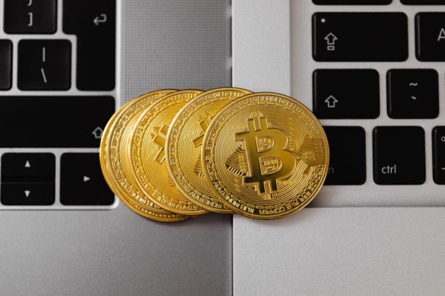 Photo of 4 bitcoins arranged next to each other on top of 2 laptops to illustrate ASIC miners Photo of 4 bitcoins arranged next to each other on top of 2 laptops to illustrate ASIC miners