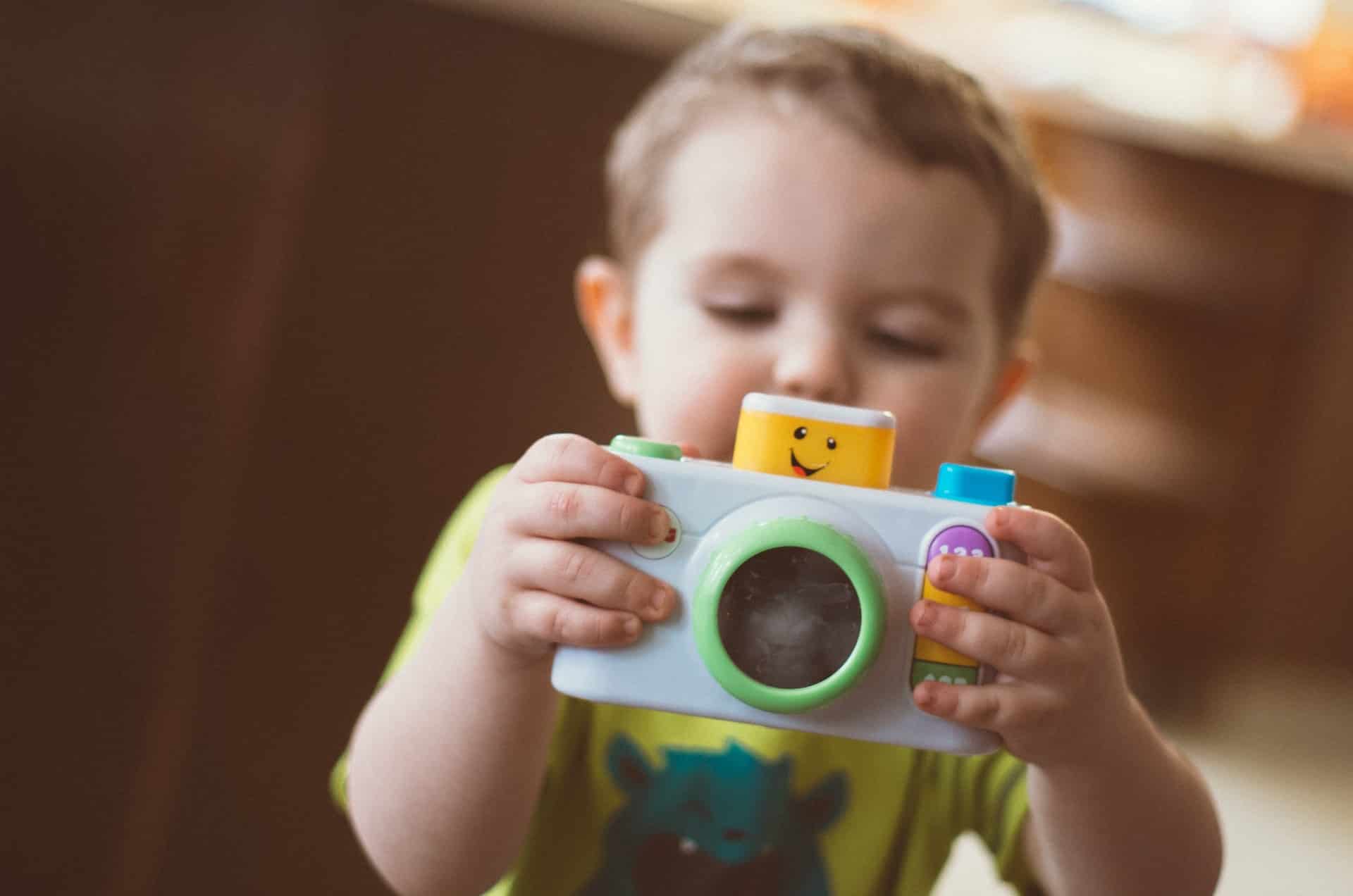 Child playing with a toy camera.