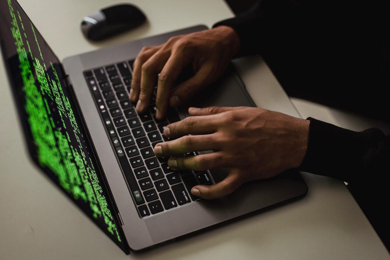 Photo of a hacker typing something on the computer