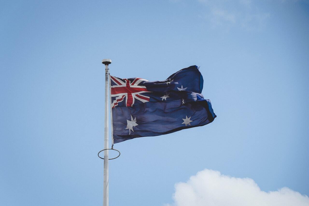 Image of Australian flag on a pole outside to illustrate the topic of crypto exchange Australia