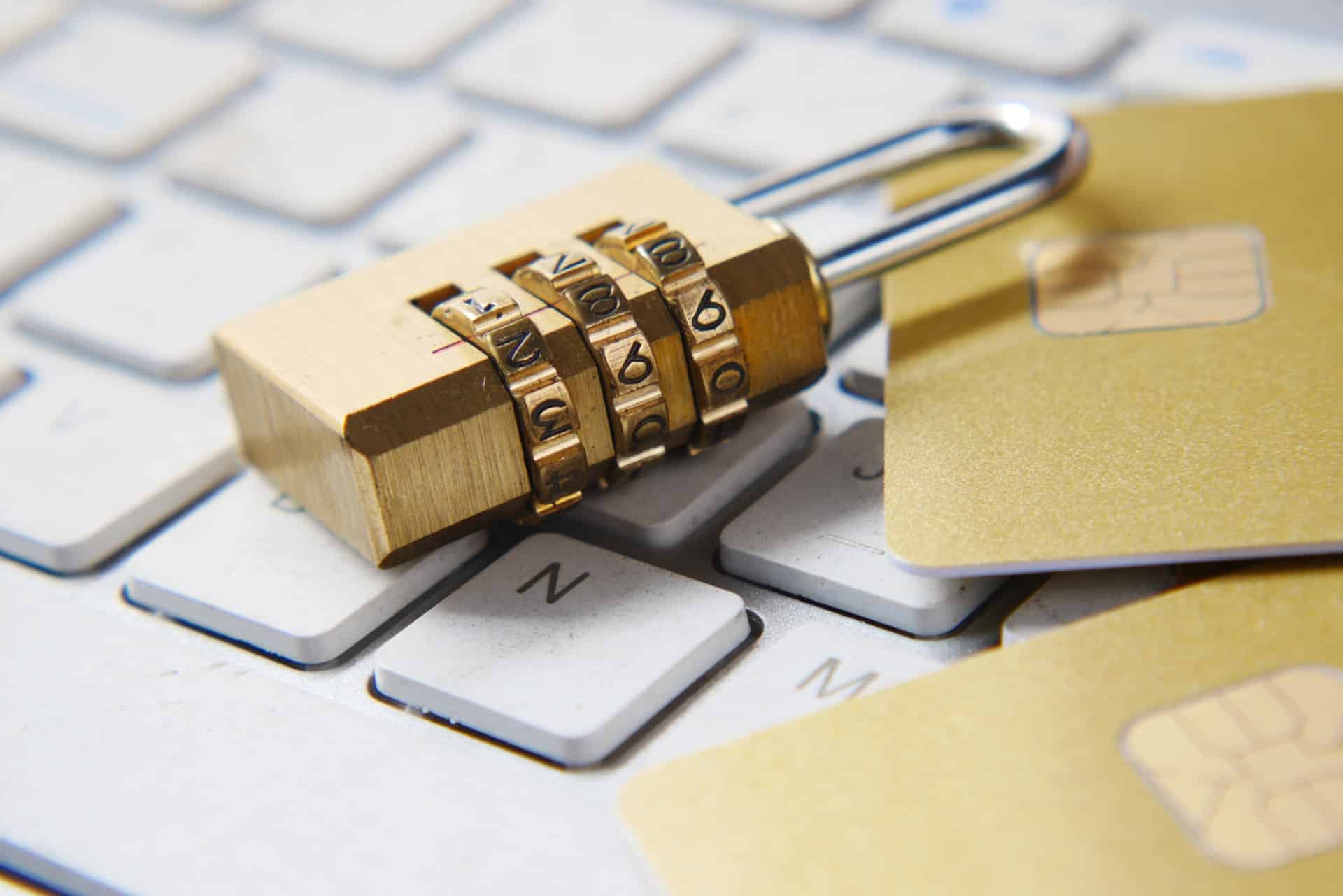 Combination lock and debit cards on top of a keyboard.