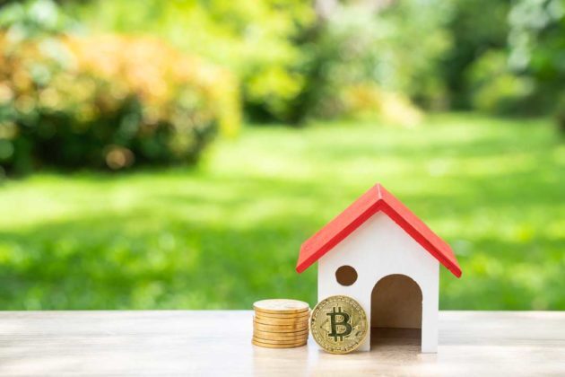 Stack of physical Bitcoins and a miniature of house