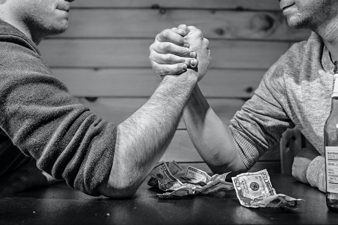 Photo of two guys arm wrestling to illustrate the idea of what is proof of work