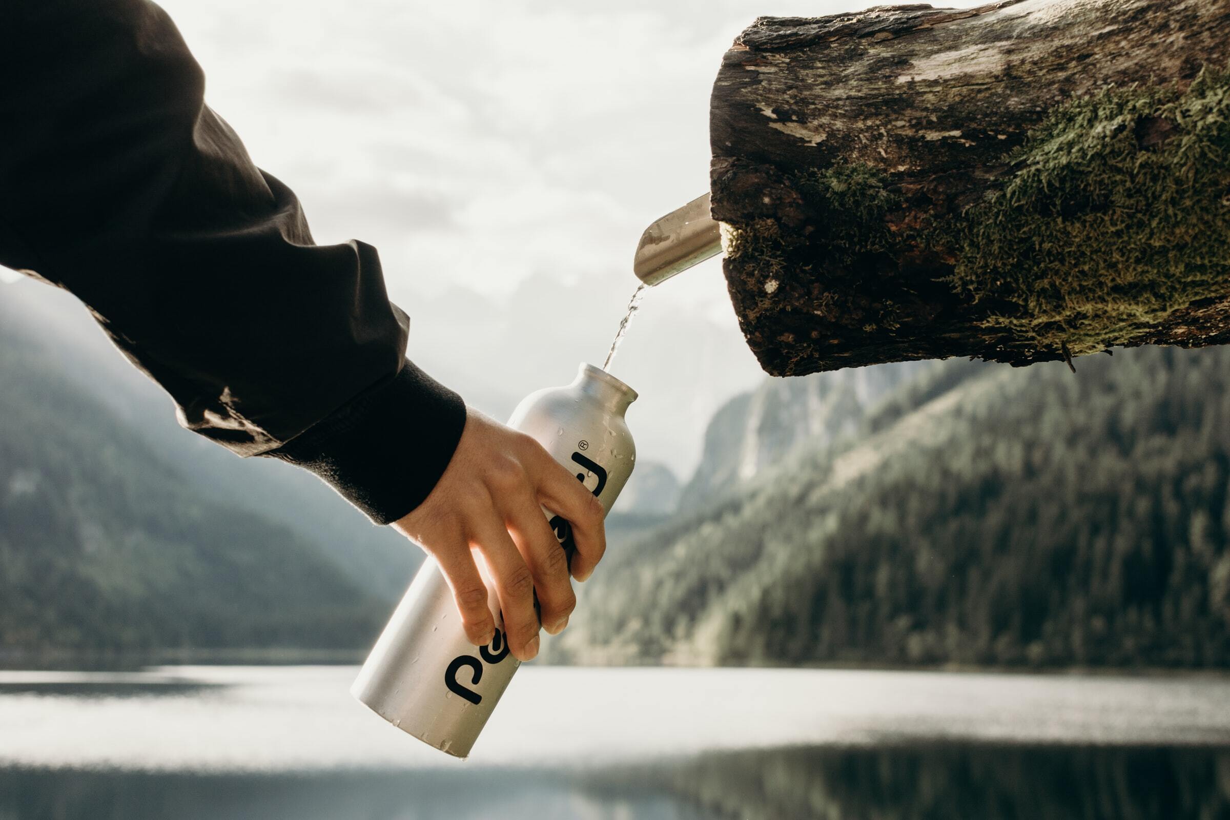 Man refills a drink from a natural tap.