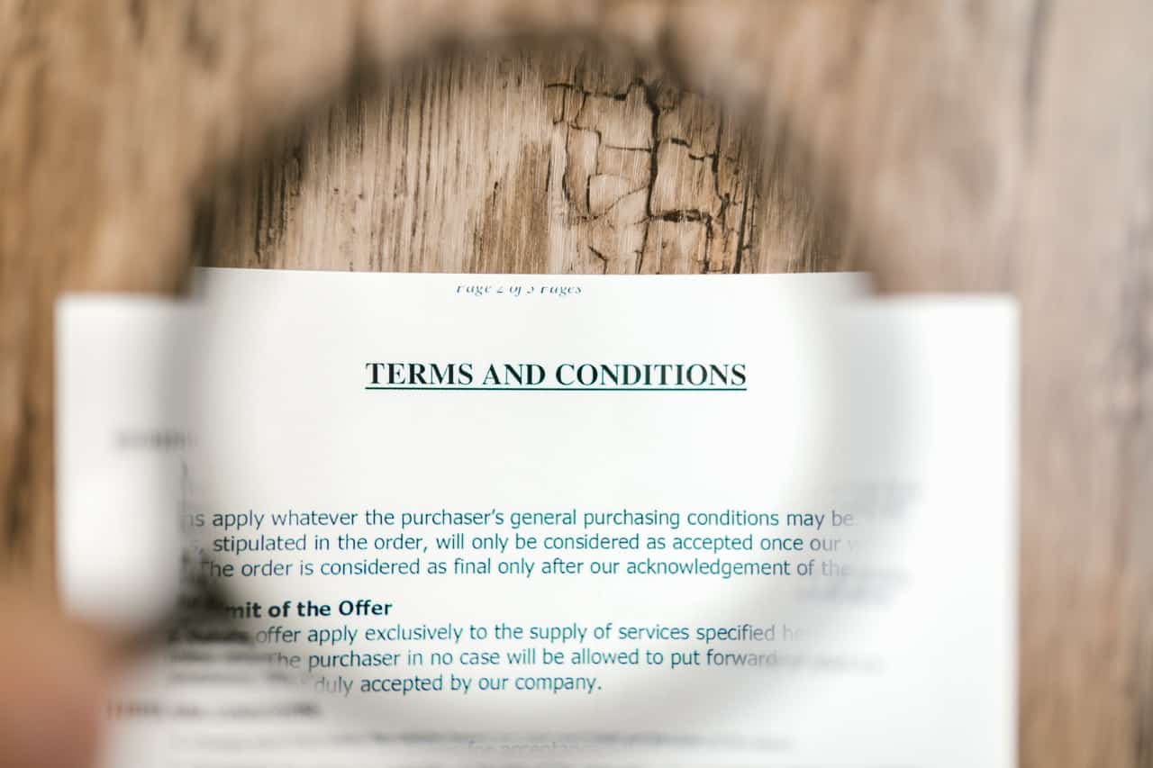 Terms and conditions on paper zoomed in with a magnifying glass.