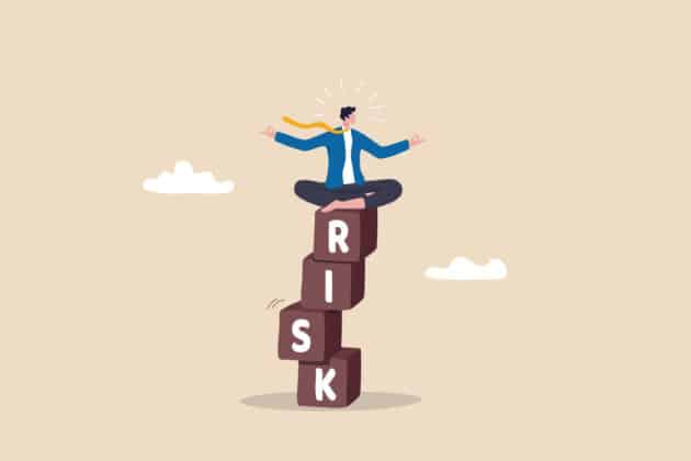 Illustration of a man balancing on top of blocks that spell out RISK Illustration of a man balancing on top of blocks that spell out RISK